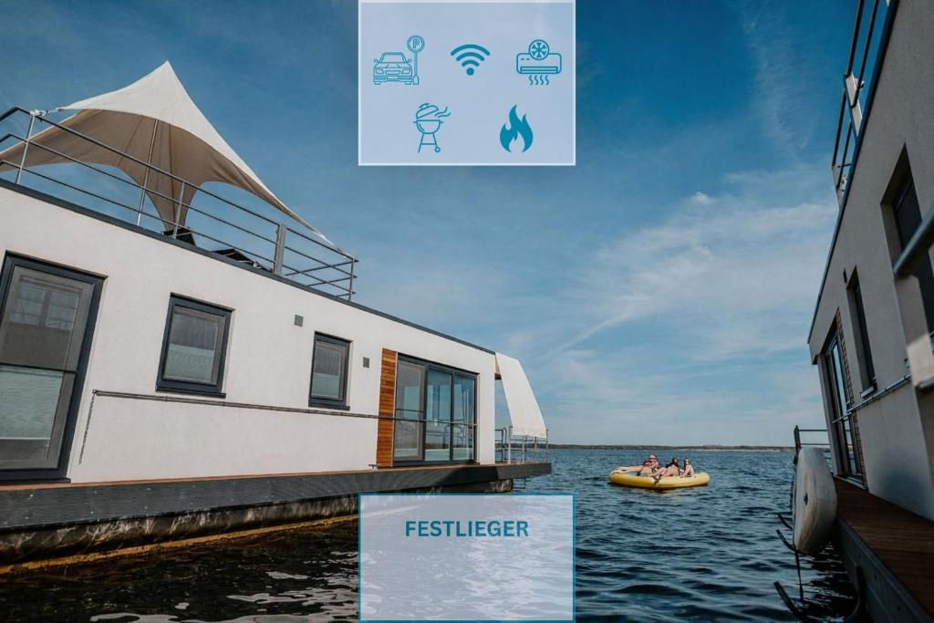 people in a boat in the water next to a dock at Floatinghouse Auszeit - LP11 in Vetschau
