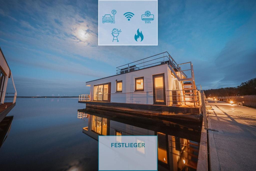 a house on a dock in the water at night at Floatinghouse Seeschwäche - LP12 in Vetschau