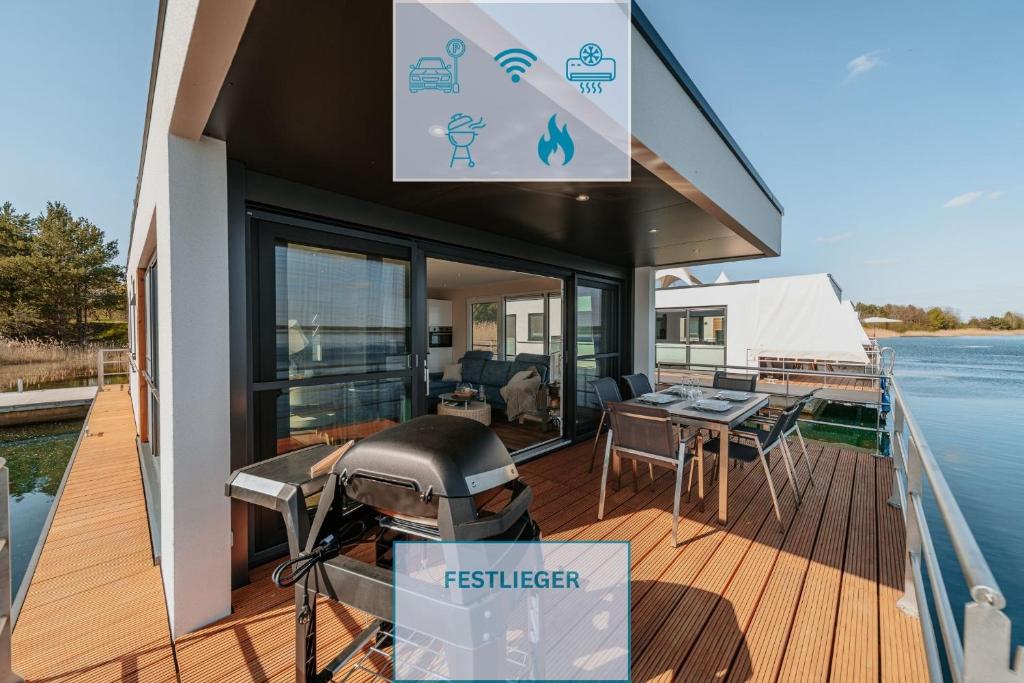 a house with a grill on the deck of a boat at Floatinghouse Seelenbaumler - LP13 in Vetschau