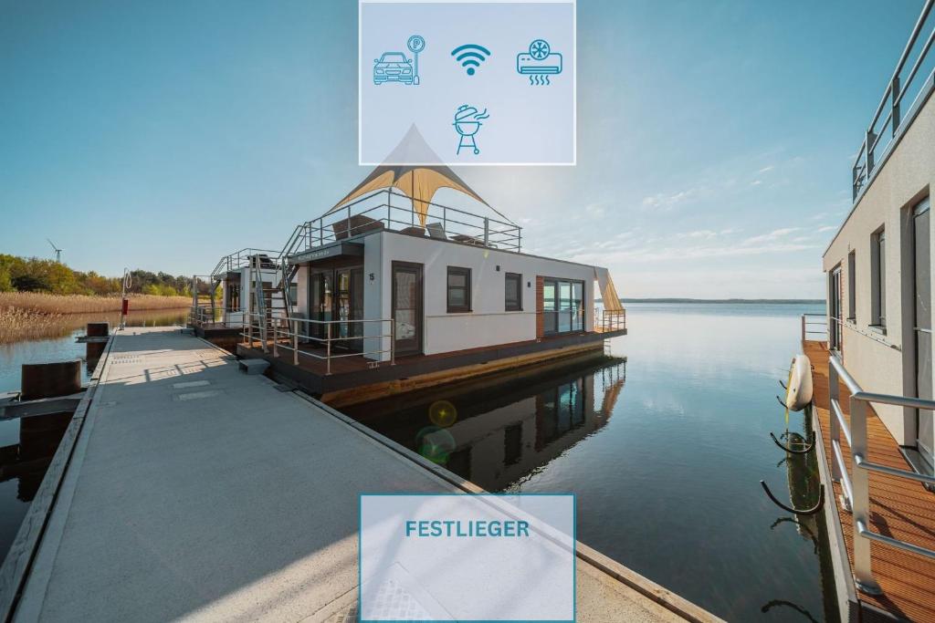 a ferry building on the water next to a building at Floatinghouse Möweninsel - LP15 in Vetschau