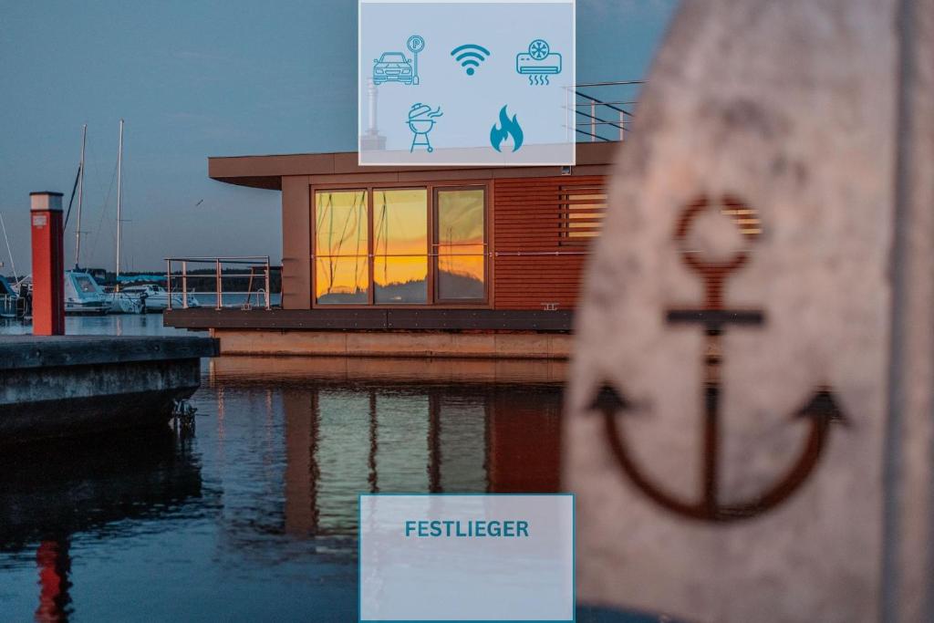a sign in front of a building on a body of water at Floatinghouse Bellini in Klitten