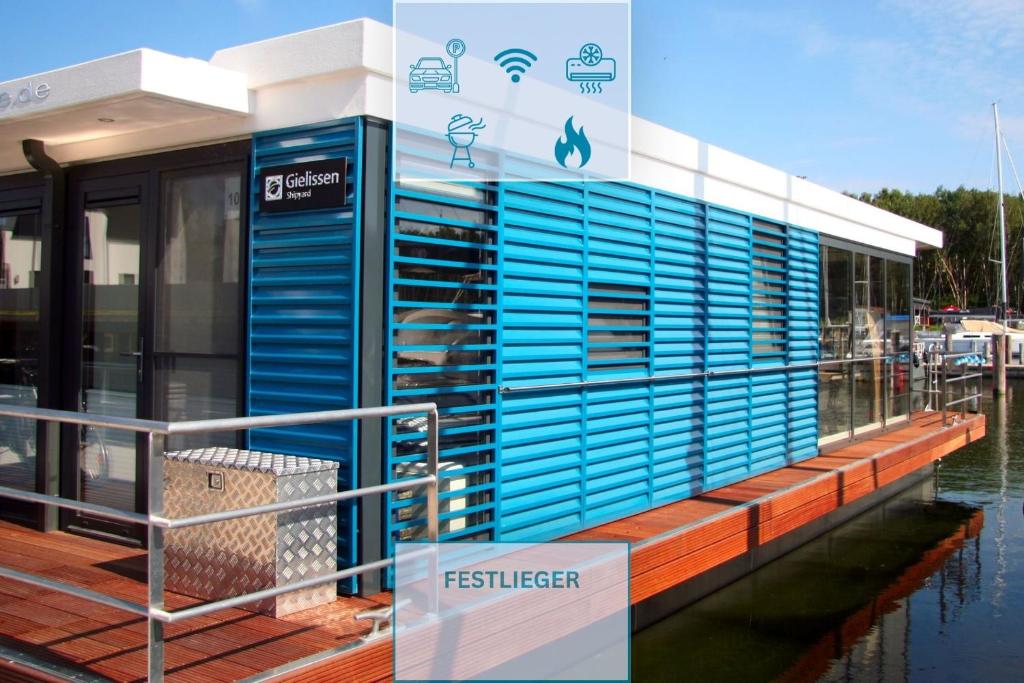 a building with blue siding on a marina at Floatinghouse Marama - LP10 in Peenemünde