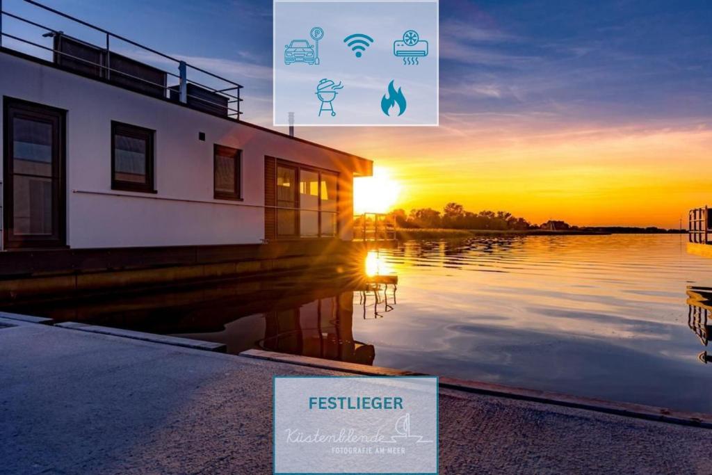 a sign in front of a body of water with the sunset at Floatinghouse Arielle in Ribnitz-Damgarten