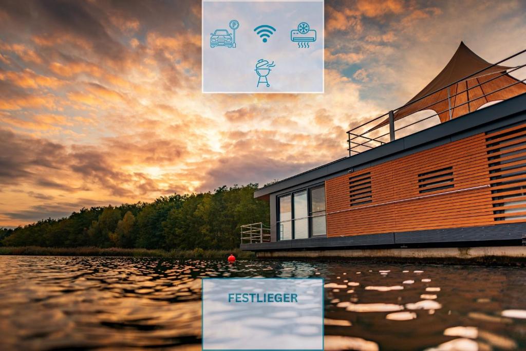 a building on a body of water with a sunset at Floatinghouse Möwe 4 - LP4 in Vetschau
