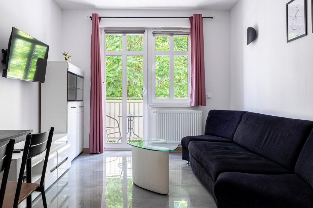 a living room with a couch and a glass table at Świętego Mikołaja 14 Centrum in Głogów