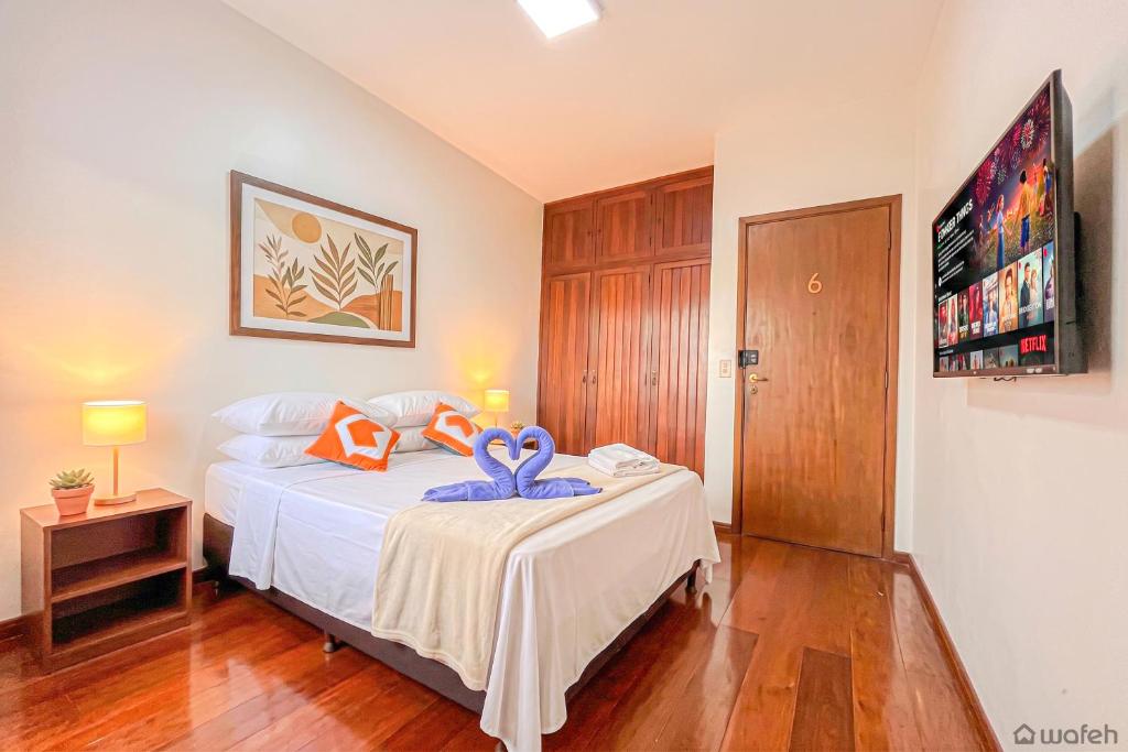 a bedroom with a bed with a blue bow on it at Wafeh Guest House - Fleming - Bar & Jardim in Belo Horizonte