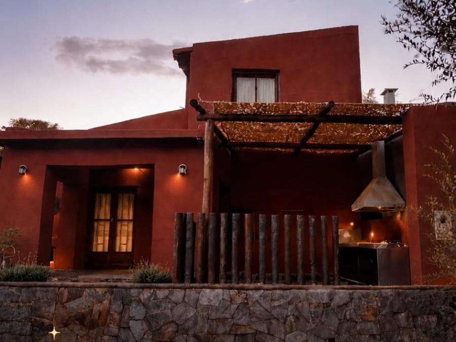 a red house with a fence in front of it at Cabañas Inti Raymi in Huacalera