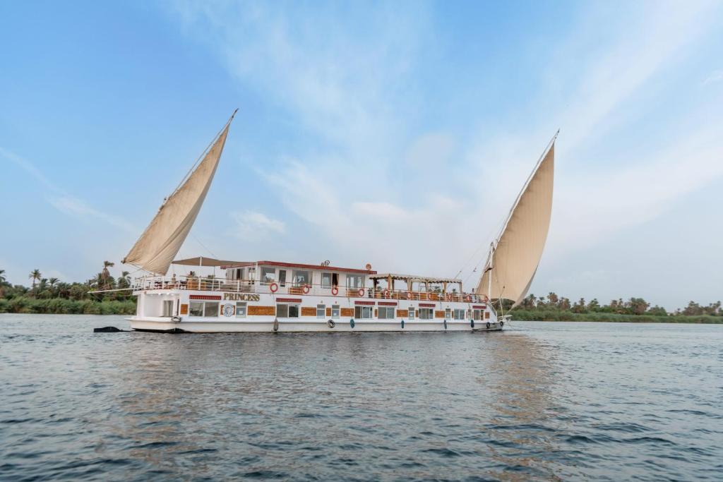 a boat with two large sails on the water at Crociera sul Nilo Luxury in Luxor