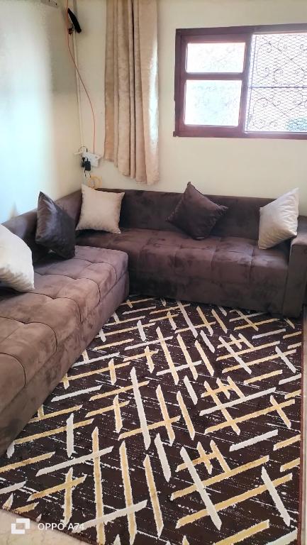 a living room with a brown couch on a rug at شقق دبي مفروشة in Tarfaya