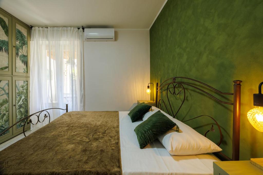 a bedroom with a large bed with green walls at Catherine's Home Central Apartment in Taormina