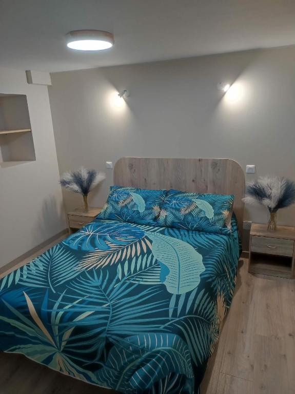 a bedroom with a bed with a blue comforter at "La maison fleurie" Sud Vendée 85 in Avrillé