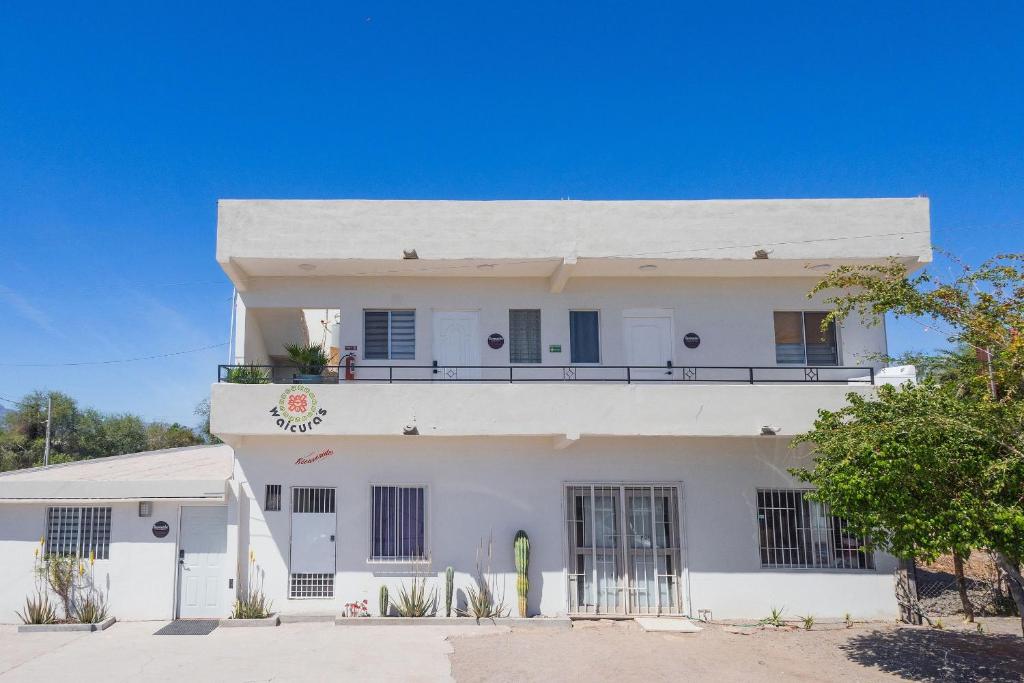 a white building with a balcony on top at Depas Waicura s in Loreto