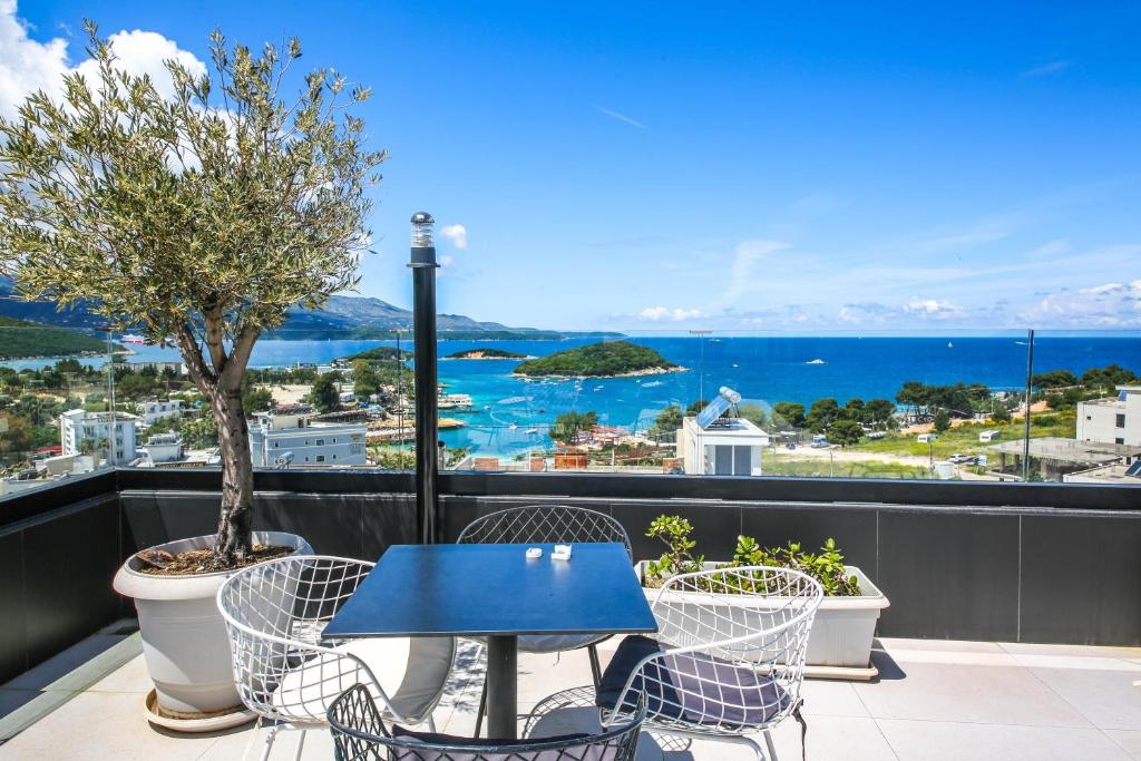 a blue table and chairs on a balcony with a view of the ocean at Rumani 3 Islands Hotel in Ksamil