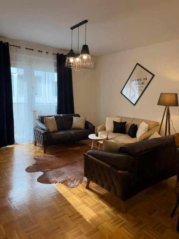 a living room with two couches and a table at Premium Apartment in Peje