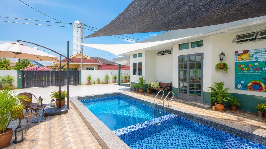 a swimming pool in front of a house at Villa Ar Raudhah Kuala Terengganu in Kampong Cherong Baru