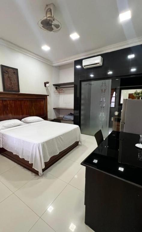 ein Schlafzimmer mit einem Bett und einem Schreibtisch in der Unterkunft Hotel Jacarandá Suites in Trinidad
