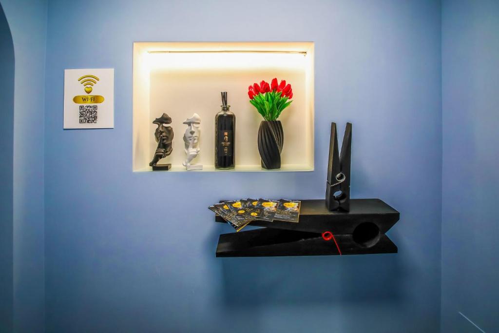 a shelf with vases and flowers on a blue wall at El Bahia Gaeta in Gaeta