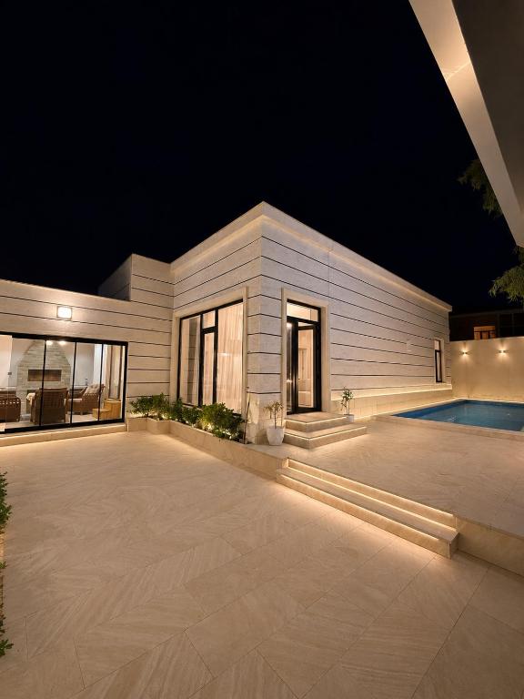 a building with a pool in front of it at night at White Dream Villa in Mərdəkan
