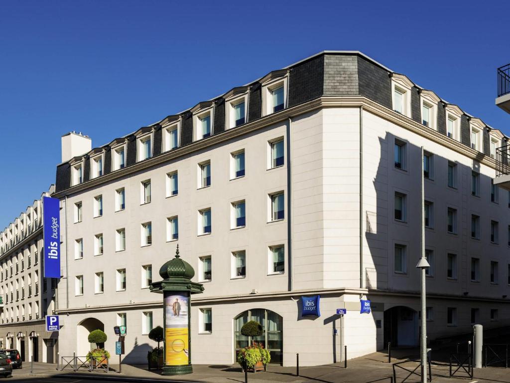 a large white building with a clock in front of it at ibis budget Meudon Paris Ouest in Meudon