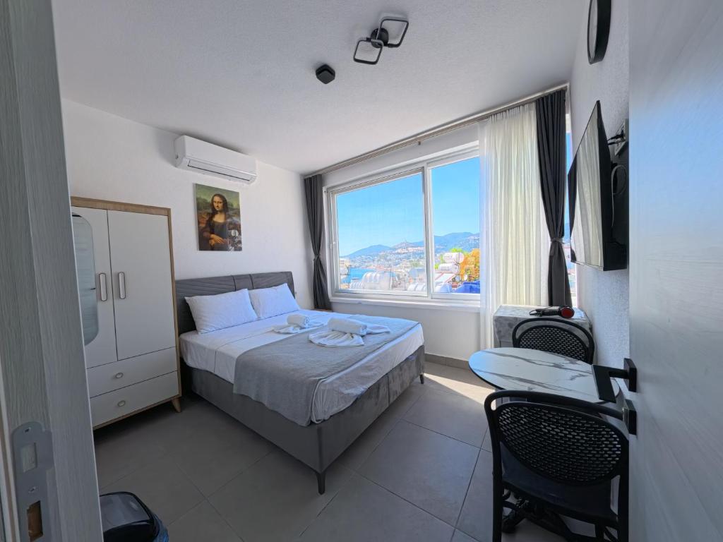 a bedroom with a bed and a large window at Merhaba Pansiyon in Bodrum City