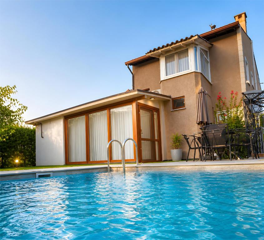 a house with a swimming pool in front of a house at Villa Jasmine in Kartepe