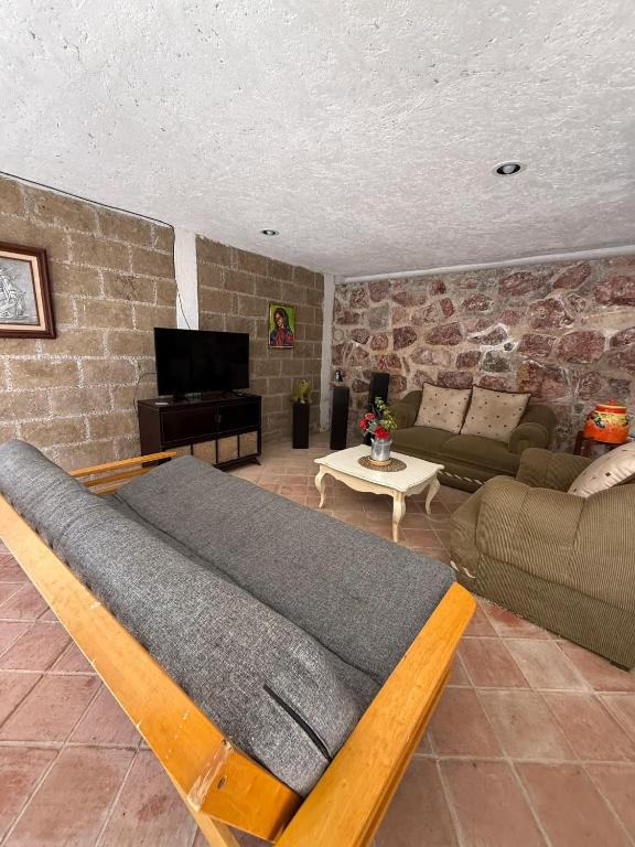 a living room with a couch and a tv at Jardin Quinta las Fuentes in Santo Tomás Chautla