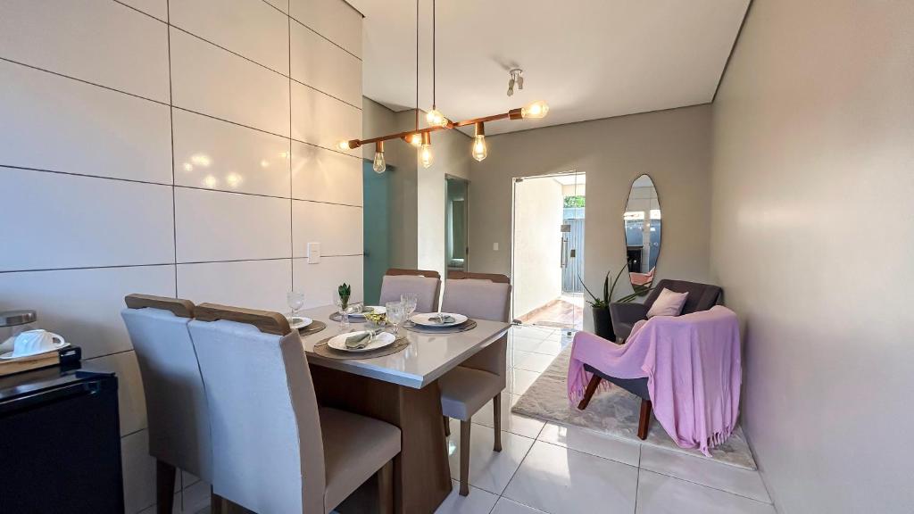 a dining room with a table and purple chairs at Rosa Serena - Conforto, silêncio e garagem - Casa com 2 quartos, próximo a rodoviária e aeroporto in Palmas