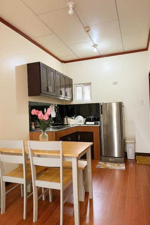 a kitchen with a table and chairs and a refrigerator at Audi's Serviced Apartment in Puerto Princesa City