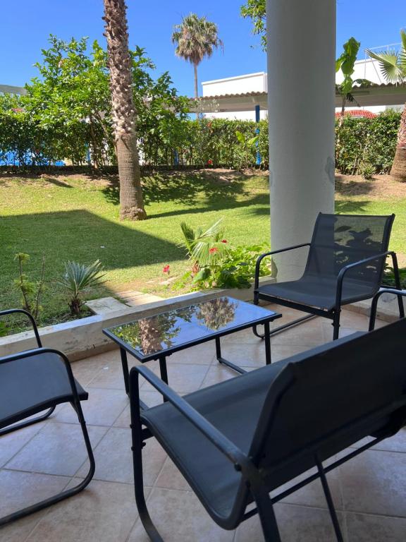 a patio with two chairs and a glass table at Apparemment marina smir in Marina Smir
