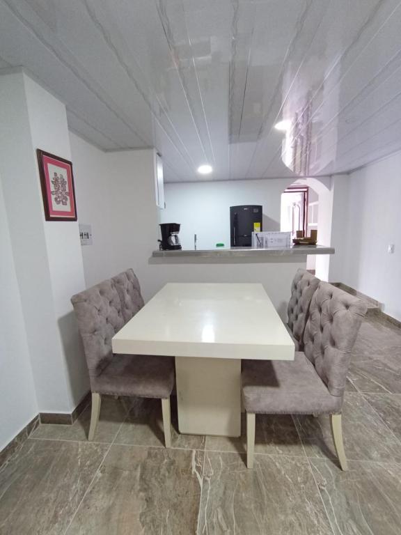 a white table and two chairs in a room at Hospedaje La Tebaida in La Tebaida