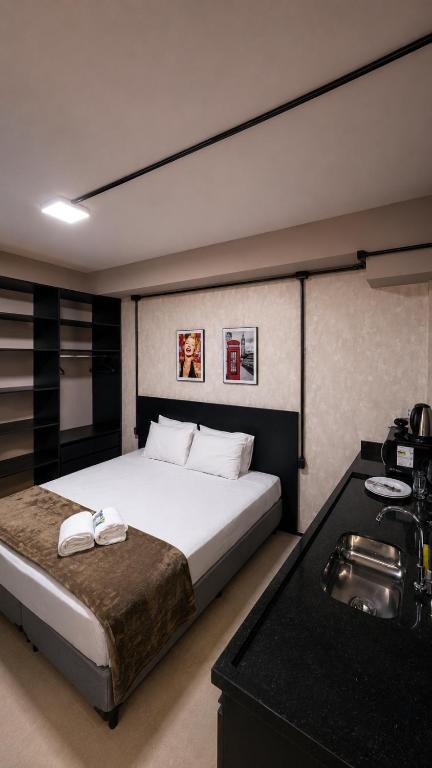 a bedroom with a large bed and a sink at ADD Hóteis Congonhas in São Paulo