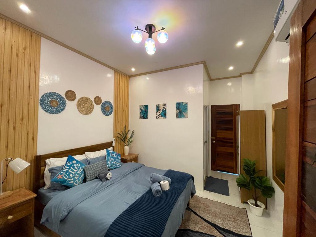 a bedroom with a large bed with blue pillows at A-rena Homestay in General Luna