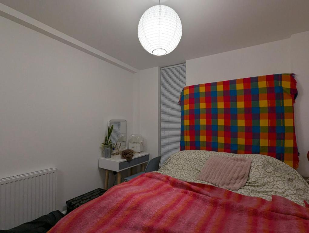 a bedroom with a bed with a colorful blanket at Cosy Centre in Dundee