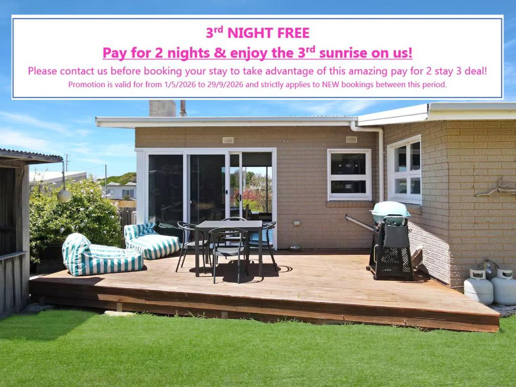 ein Flyer für eine Terrasse mit Tisch und Stühlen in der Unterkunft Cutback Cottage in Scamander