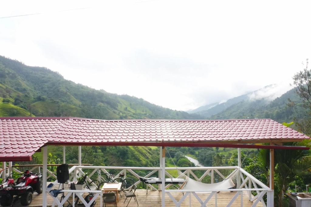 a gazebo with a table and chairs and mountains at villa los recuerdos in Jarabacoa