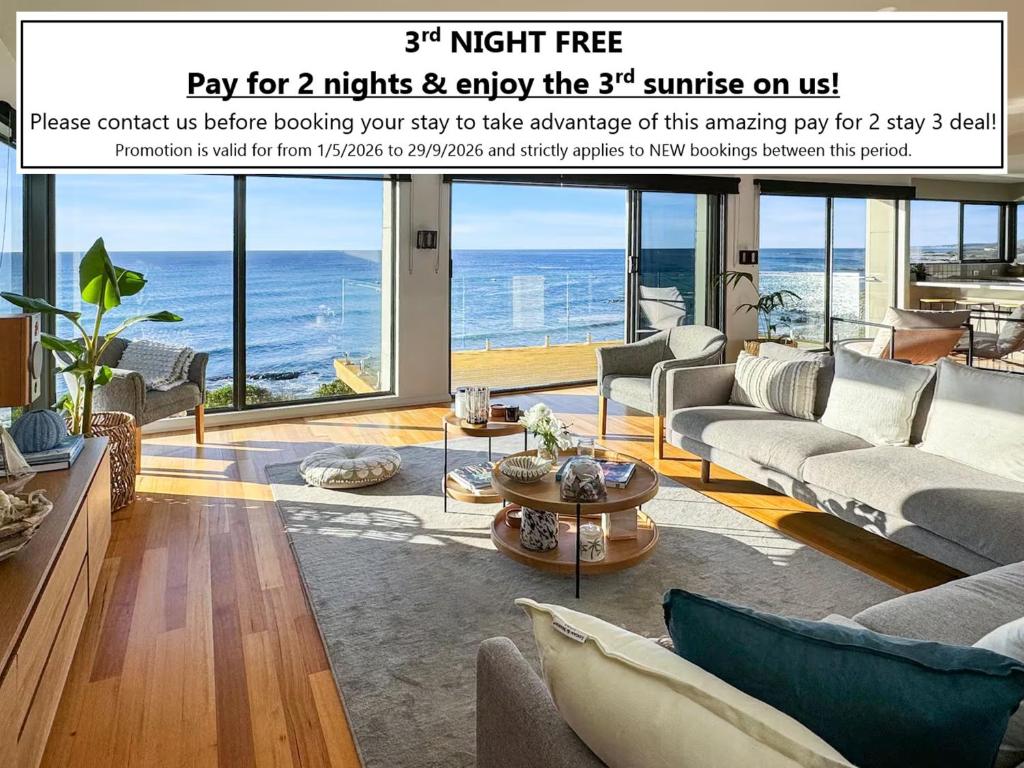 a magazine advertisement for a living room with a view of the ocean at Ava - Luxe Oceanfront Beach House in Falmouth