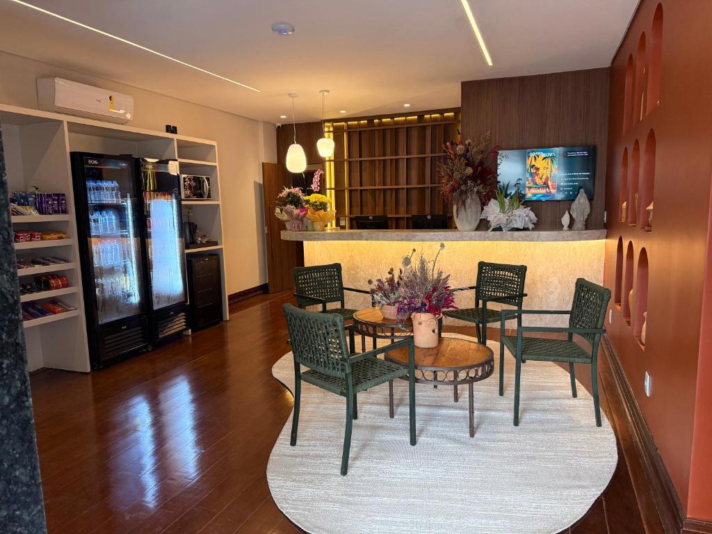 a dining room with a table and chairs and a kitchen at POUSADA MILÊNIO LTDA in Ponte Nova