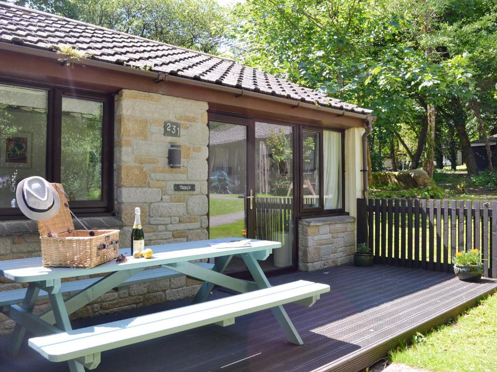 a picnic table on a deck next to a building at Happys in St Ives