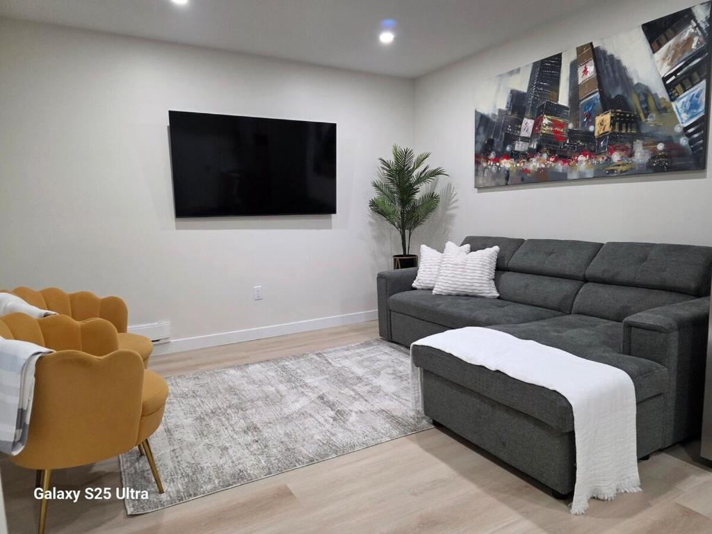 a living room with a couch and a flat screen tv at Executive Luxury Suite Unit B in Regina