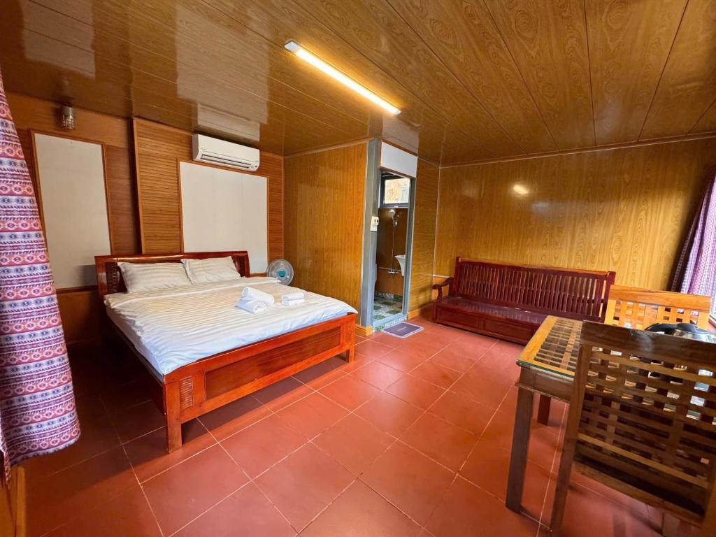 a bedroom with a bed and a bench in a room at Resort Đồi Thông in Kon Von Kla