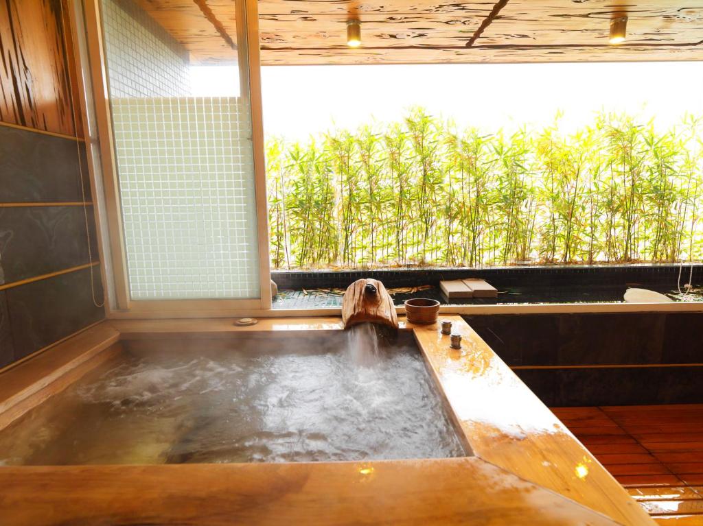 a bath tub in a room with a window at Sun Moon Bed& Breakfast 日月民宿 in Wulai