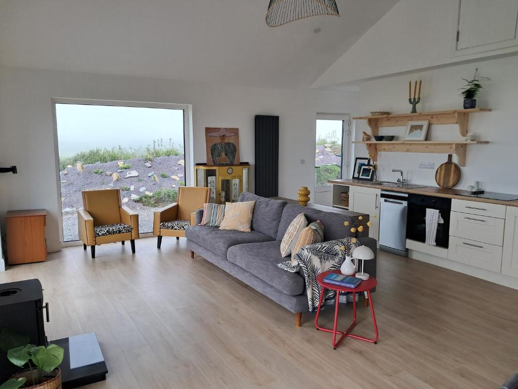 a living room with a couch and a kitchen at Tigh Droum in Rosscarbery