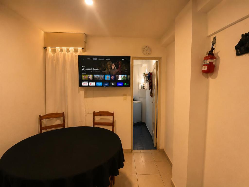 a room with a table and a television on the wall at Depto Termas Centro in Termas de Río Hondo