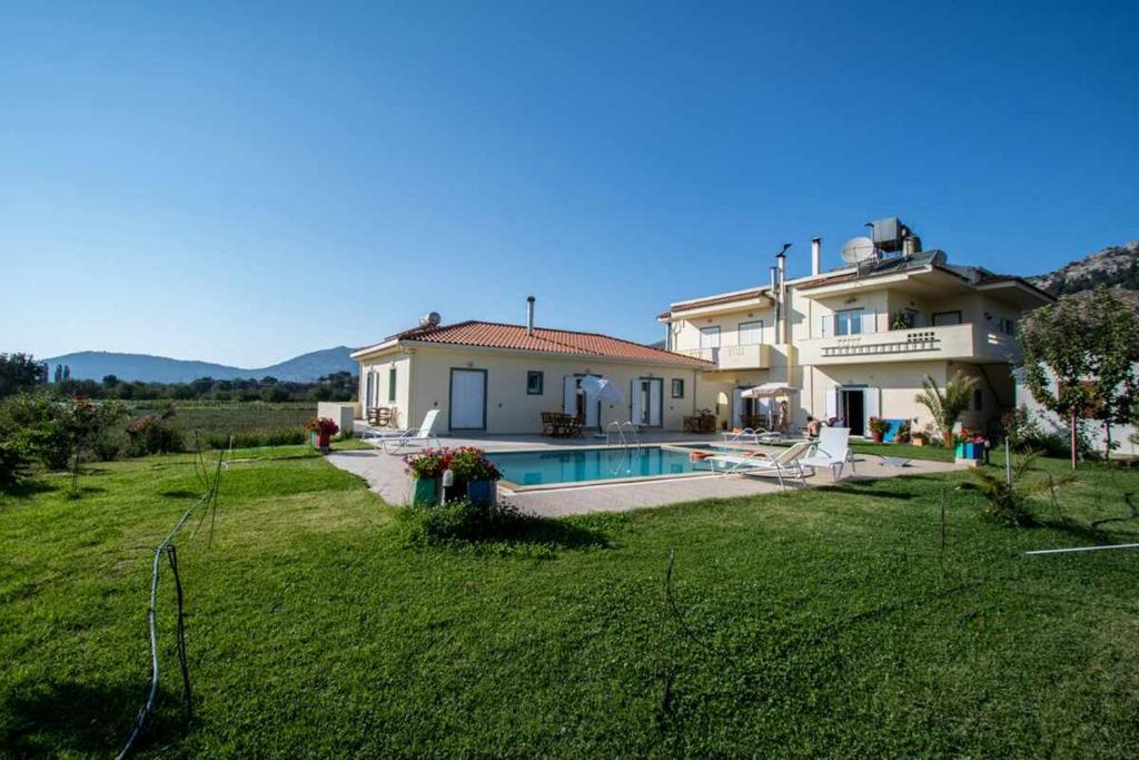 una casa grande con un patio con piscina en Maison Kronio Lassithi Plateau en Marmakéton