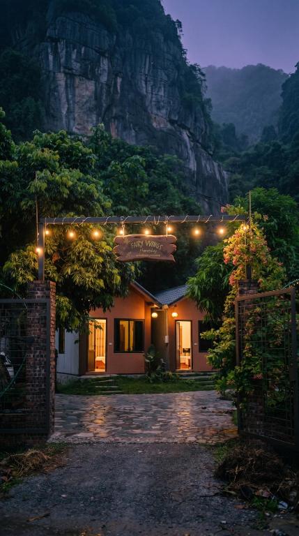 a building with lights on it in front of a mountain at Tam Cốc FAIRY WINGS Homestay in Vũ Lâm
