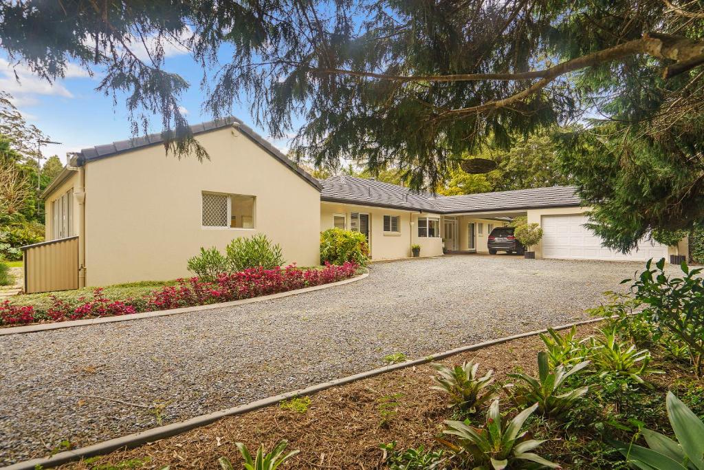 a large white house with a driveway at Hideaway with us, on Tamborine Mountain in Mount Tamborine