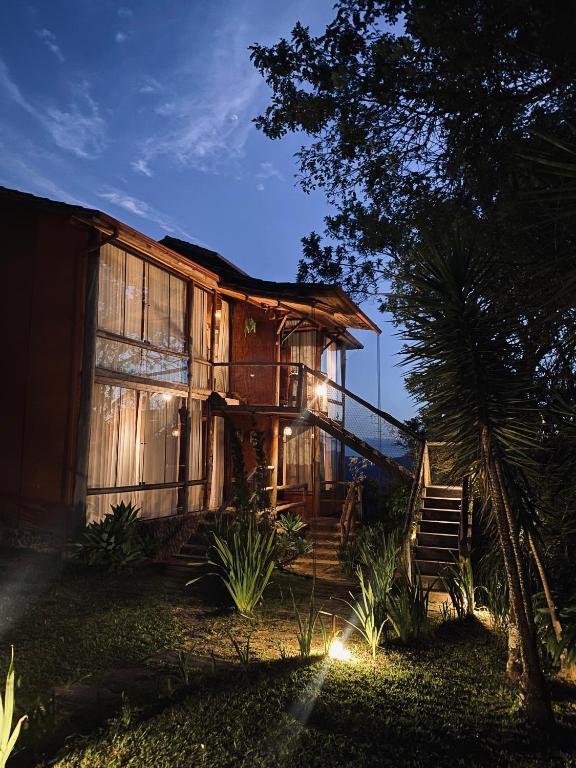 a wooden house with stairs leading to it at night at Suítes Ad`vinho in Lavras Novas