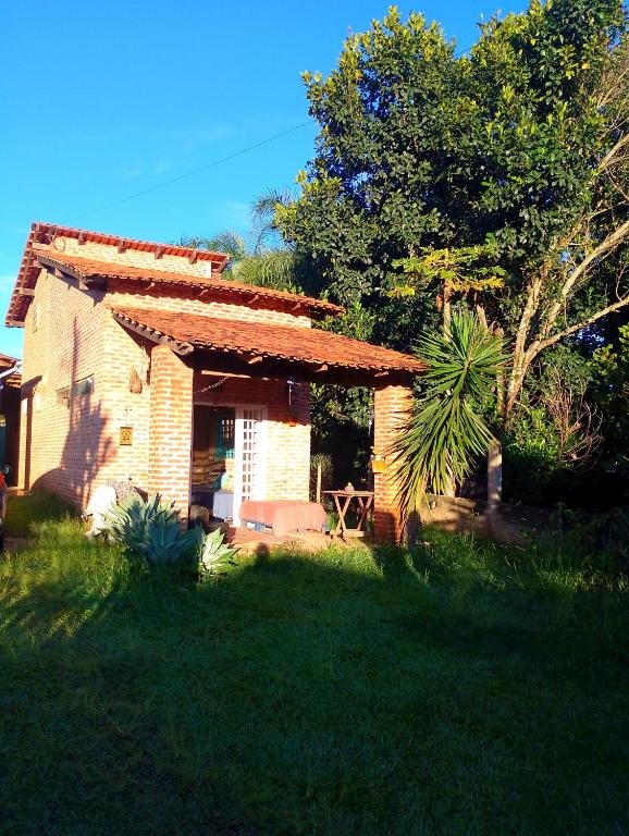 a small brick house in a grassy yard at Espaço Além da Lenda in Alexânia