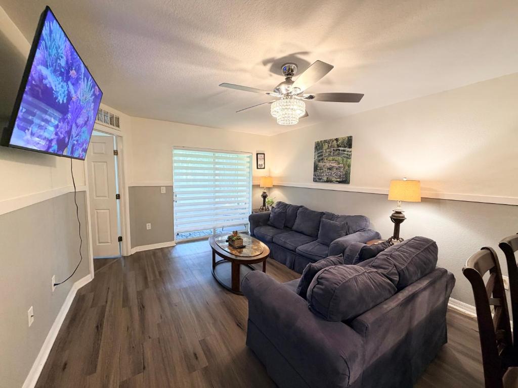 a living room with a couch and a flat screen tv at Disney Kissimmee Condo in Kissimmee