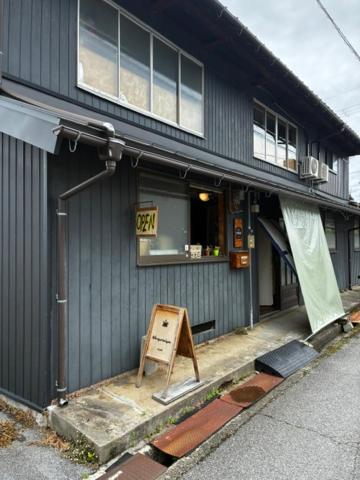 a black building with a sign in front of it at GUEST HOUSE NAGORIYA in Hikone